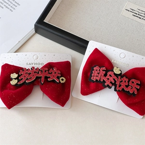 Detailed view of red velvet bow hair clips with festive Suisui Pingan and New Year text