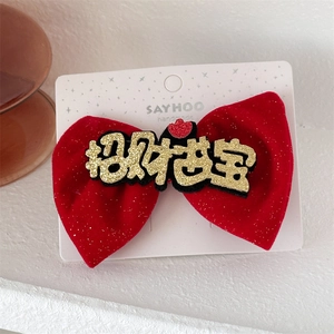Detail of red velvet bow hair clip featuring golden glitter Chinese characters and heart