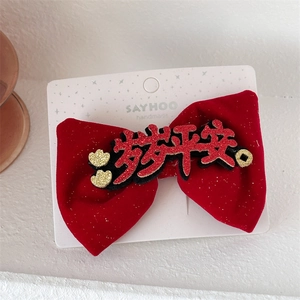 Detail of red velvet bow hair clip with gold Suisui Pingan festive Chinese lettering
