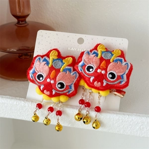 Détail des barrettes de Nouvel An avec broderie dragon, glands et cloches dorées