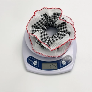 Detailed view showing the 17.4g weight of the red plaid lace hair scrunchie on a scale