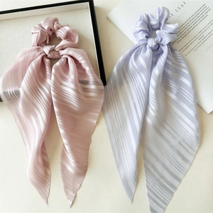 Détail de chouchous longs élégants en rose clair et violet avec texture subtile