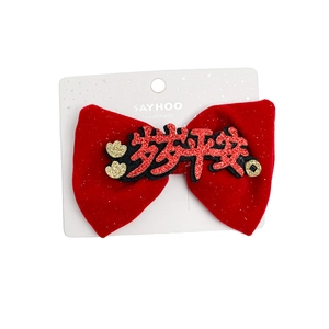 Red velvet New Year hair clip with festive gold lettering and elegant bow design