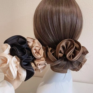 Macro shot showing the glossy satin texture and pleated design of oversized scrunchies