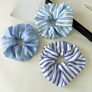 Dreiteiliges Set aus blau-weiß gestreiften Stoff-Haargummis im minimalistischen Stil