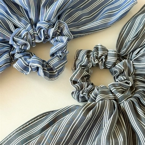 Detail view of large striped scrunchies in navy blue and charcoal grey fabrics