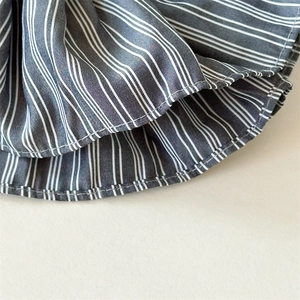 Detailed close-up of high-quality sewing and white stripe patterns on dark gray fabric