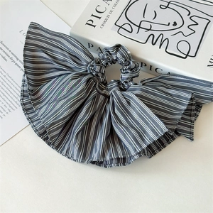 Macro shot of grey striped pleated hair scrunchie with detailed fabric texture