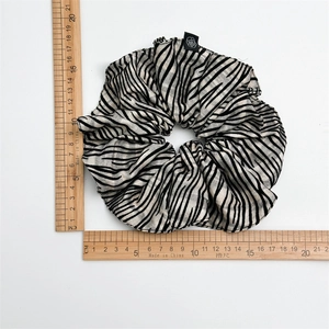 Macro detail of large zebra print hair scrunchie showing 14cm diameter size on white background
