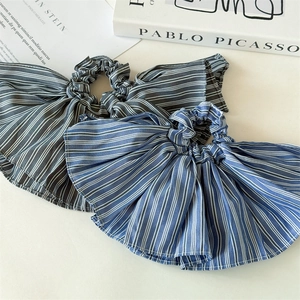 Detailed close-up of blue and grey striped oversized bow scrunchies with woven texture