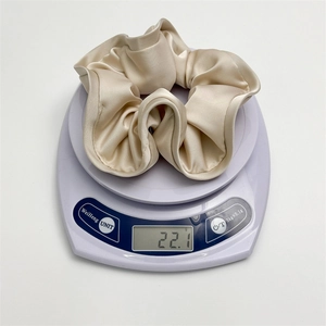 Detail shot of large champagne satin scrunchie on electronic scale showing 22.1g weight