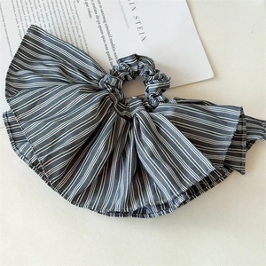 Detail of elegant black and white striped scrunchie with oversized ruffle design