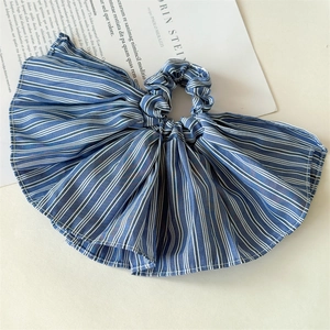 Detailed view of large blue and white striped fabric scrunchie with wide pleated edges