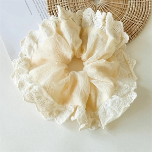 Close-up of cream lace oversized scrunchie showing delicate floral embroidery and texture