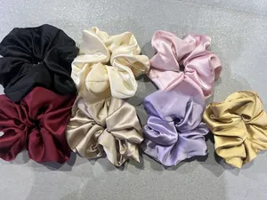 Dettaglio di elastici scrunchie in raso setoso in sette colori con finitura perlata