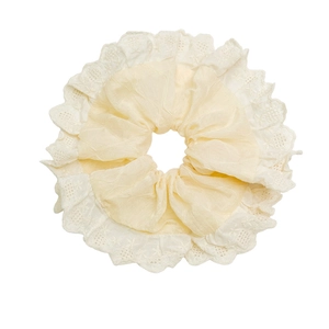 Sweet apricot scrunchie with detailed white lace trim and soft pleated texture