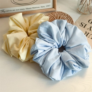 Chic oversized scrunchies in pale yellow and light blue with soft pleated fabric texture