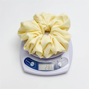 Detailed scale view showing the 28.6g weight of this creamy yellow large cloud scrunchie