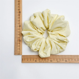 Size measurement of the large cream yellow cloud scrunchie showing a 14-15cm diameter