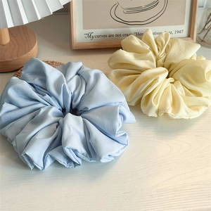 Detail of light blue and soft yellow oversized scrunchies in a cozy home setting