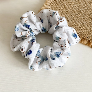 Chouchou floral en mousseline avec motif de fleurs bleues sur tissu gaufré doux