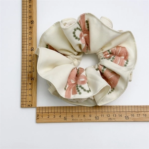 Elegant off-white scrunchie with pink floral embroidery and lace trim, 11cm diameter
