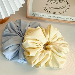 Close-up of light blue and yellow oversized scrunchies with rich fabric texture