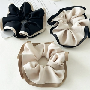 Three-piece set of elegant ruffled scrunchies with contrasting edges in neutral tones