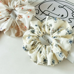 Vue détaillée de deux chouchous en tissu floral avec des motifs d'ours et textures