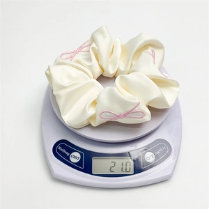 Elegant cream satin scrunchie with pink bow embroidery and a lightweight 21g design