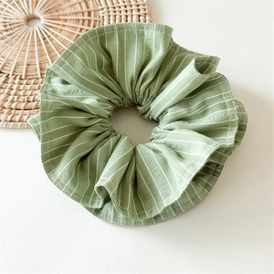 Détail du chouchou en coton à rayures vertes avec texture froissée et tissage de tissu