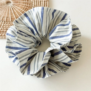 Vue détaillée du chouchou en coton à rayures bleues et blanches avec texture plissée douce