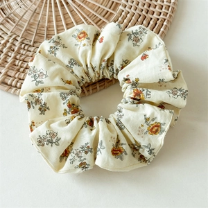 Détail de l'élastique à cheveux floral avec motifs de baies sur tissu en coton beige