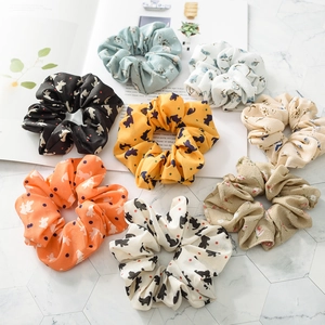Assorted scrunchies with cute cat print and floral patterns on marble background