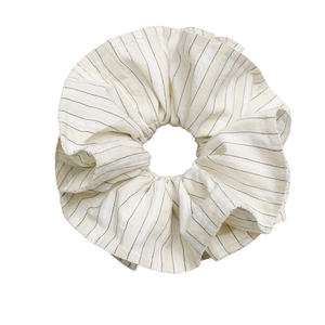 Chouchou en coton à rayures blanc crème avec design à volants sur fond blanc minimaliste