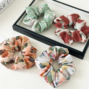 Gros plan de quatre chouchous en mousseline florale aux couleurs assorties et souples