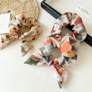 Détail de chouchous en mousseline fleurie avec nœuds élégants et motifs tie-dye vintage