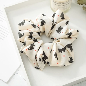 Close-up of cat print chiffon scrunchie on a white tray with aesthetic background