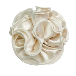 Oversized cream satin scrunchie with ruffled edges and elegant glossy texture