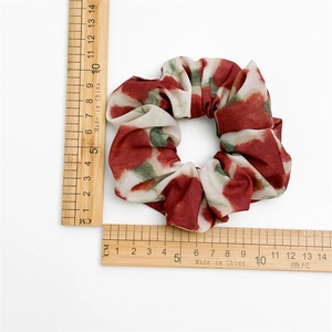 Détail d'un chouchou en mousseline tie-dye rouge et blanc avec mesure de taille sur blanc