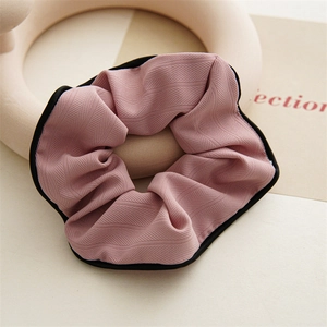 Détail d'un chouchou rose motif chevrons avec bordure noire sur support céramique