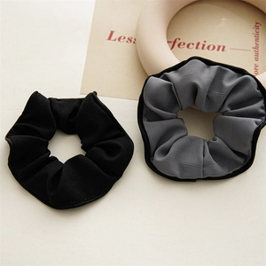 Vue détaillée des chouchous noirs et gris avec textures de tissu à chevrons fins