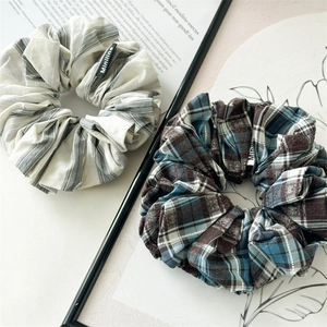 Detail of grey striped and blue checkered cotton scrunchies with black woven Miniline tags