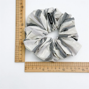 Detail of oversized black and white striped hair scrunchie with 15.5cm diameter scale