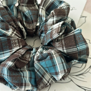Macro shot of blue and brown checkered scrunchie with intricate jacquard weave texture