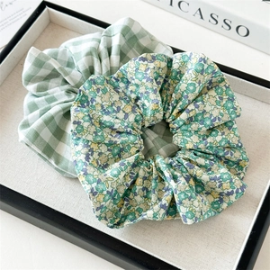 Détail de l'ensemble chouchous vert à fleurs et à carreaux sur un plateau élégant