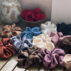 Assorted oversized satin hair scrunchies in elegant neutral and pastel colors silk texture