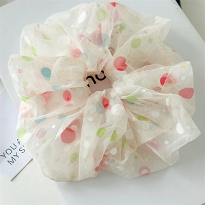 Detail of 18cm mesh scrunchie featuring colorful polka dots on creamy white fabric