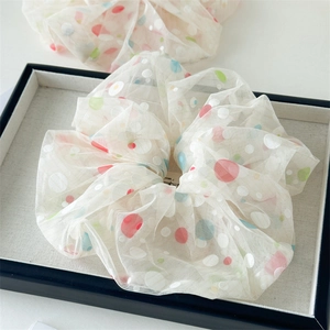 Detail of 18cm white mesh scrunchie featuring colorful polka dots and airy texture