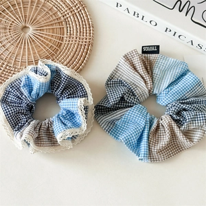 Close-up of blue plaid scrunchie set with delicate lace trim and things brand woven label